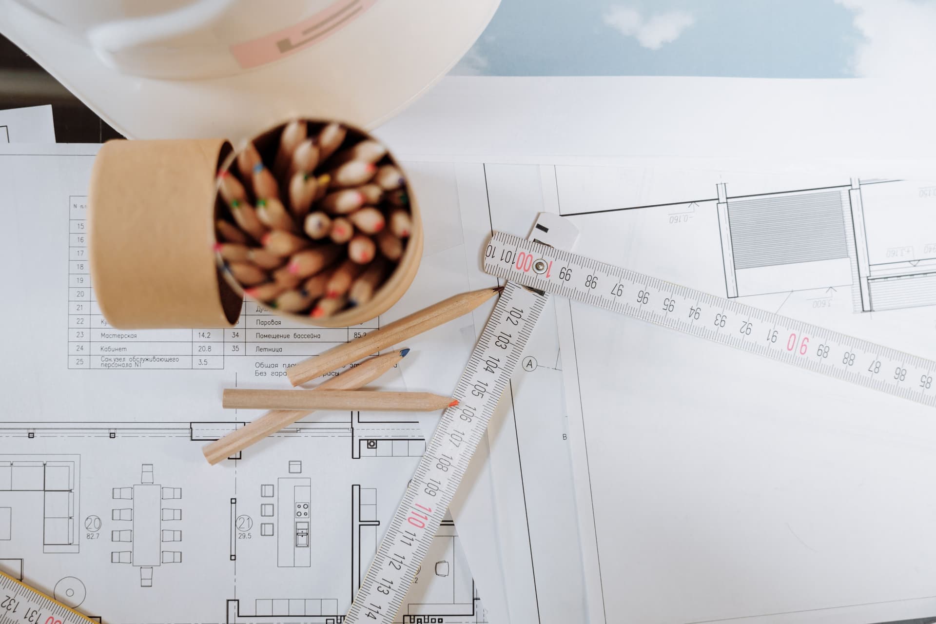A pencil, ruler and measuring square on a wooden plan