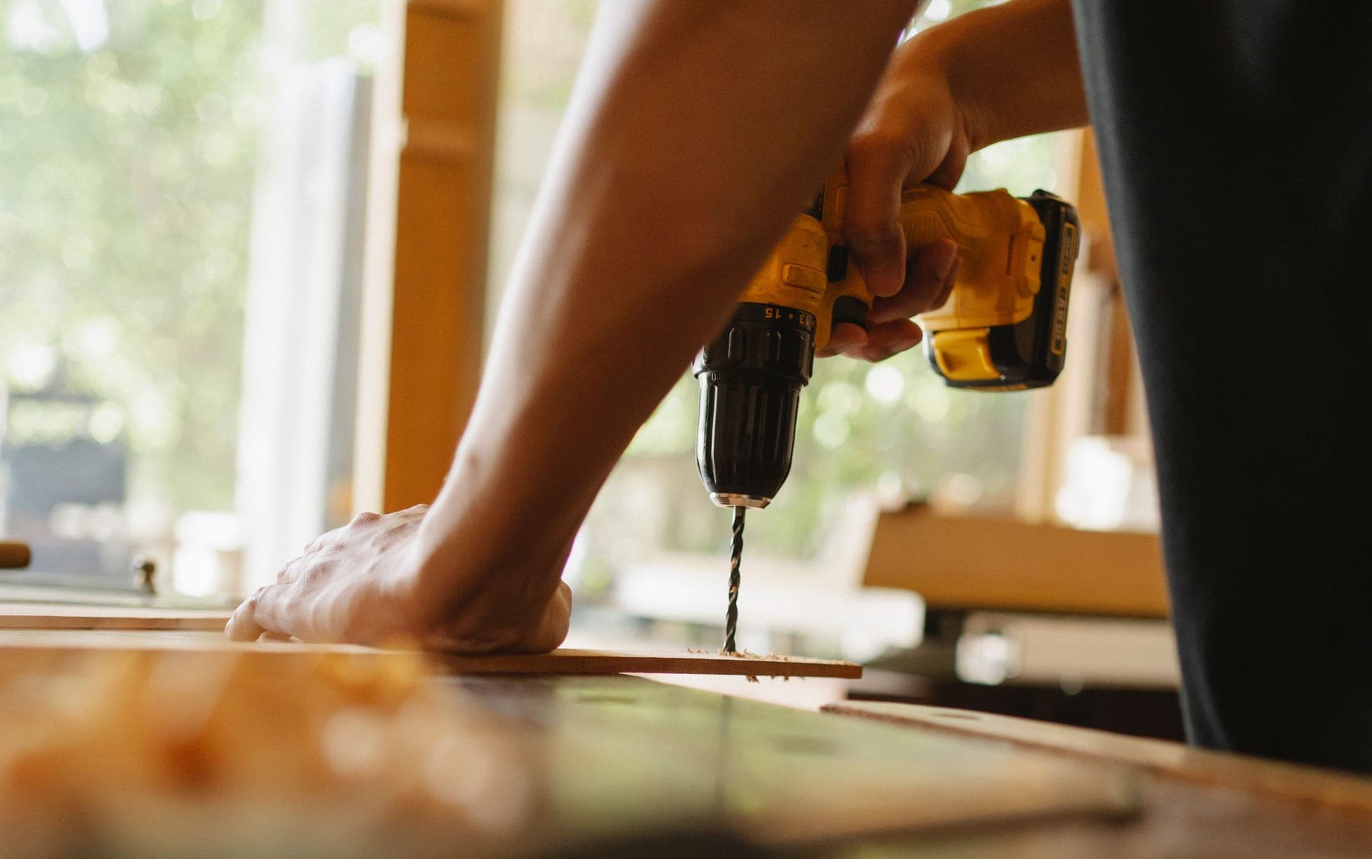 A cordless drill and power tools on a workshop bench