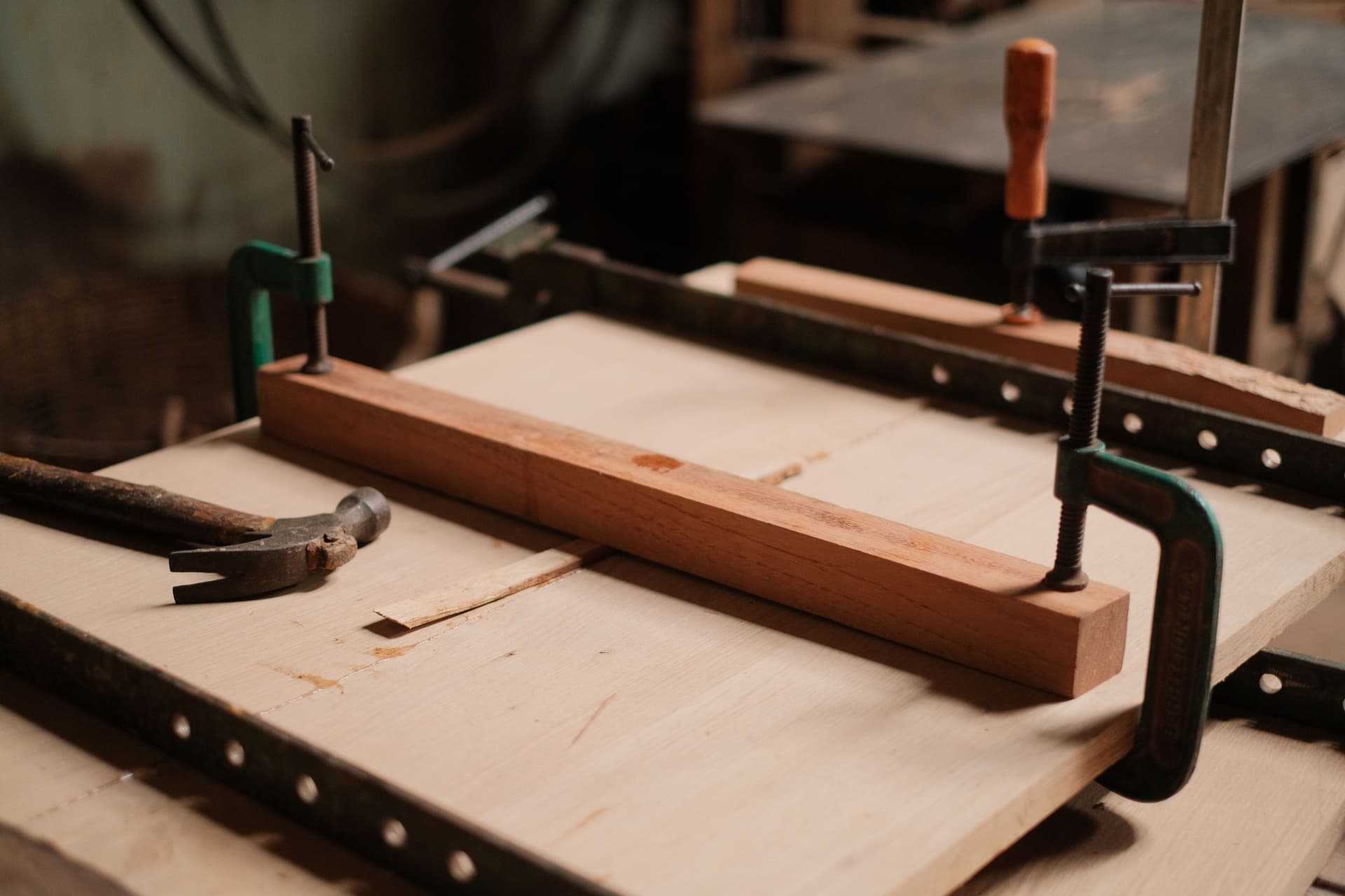 A sturdy wooden workbench with clamps and hand tools